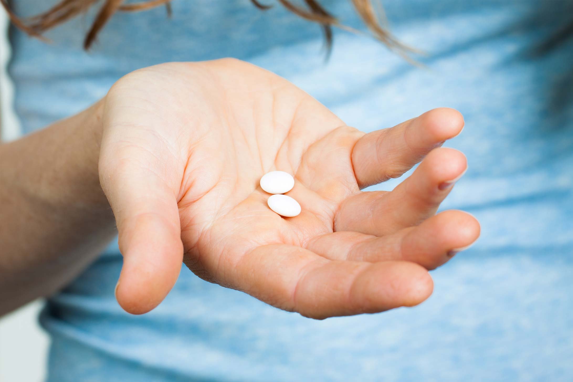 Eine Frauenhand mit zwei Tabletten