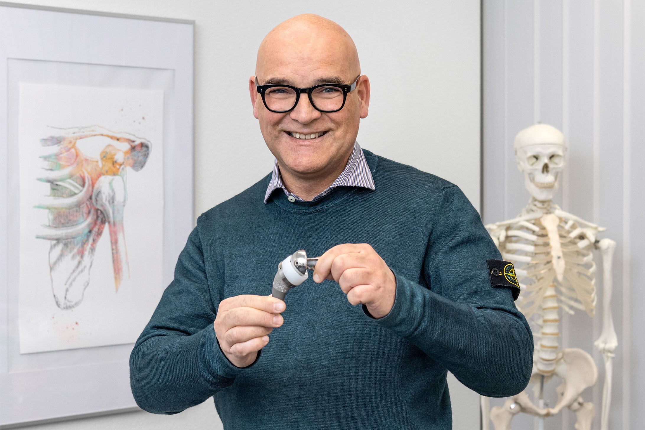 Mathias Hoffmann, Leitender Arzt Orthopädie am Spital Emmental, hält ein künstliches Schultergelenk in den Händen.